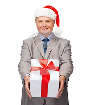 Smiling man in suit and santa helper hat with gift