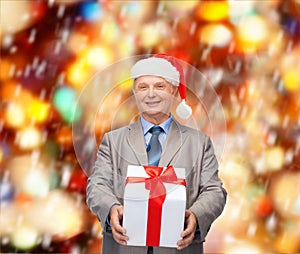 Smiling man in suit and santa helper hat with gift