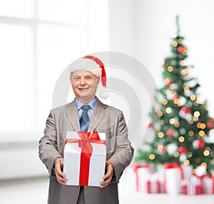 Smiling man in suit and santa helper hat with gift