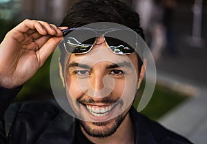 Smiling man in sunglasses with colorful reflection