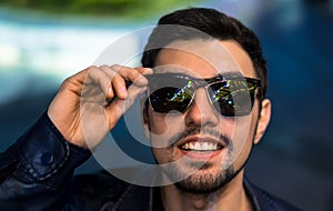 Smiling man in sunglasses with colorful reflection