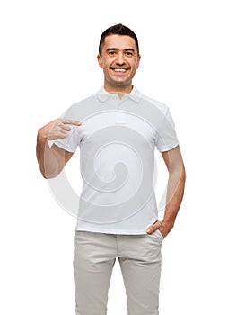 Smiling man in t-shirt pointing finger on himself