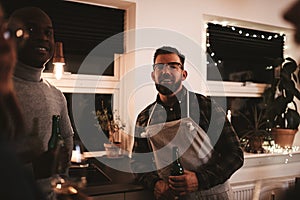 Smiling man talking with guests during a dinner party