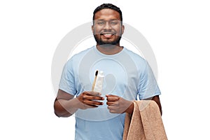Smiling man with toothbrush, toothpaste and towel
