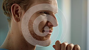 Smiling man touching chin with hand closeup. Focused bearded guy talking online