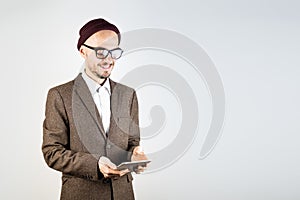 Smiling man in tweed jacket with a tablet computer.