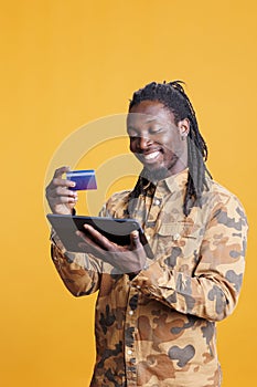 Smiling man typing credit card information
