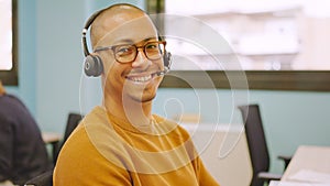 Smiling man using headset while working in a coworking