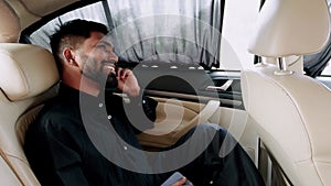Smiling man using smart phone shocking and laughing talking in luxury car interior
