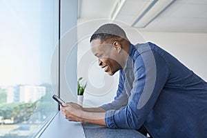 Smiling man using smartphone at office