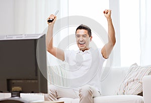 Smiling man watching sports at home