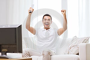 Smiling man watching sports at home