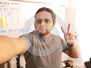 smiling man waving with gray shirt