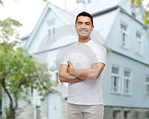 Smiling man in white t-shirt over house background