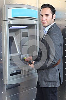 Smiling man withdrawing money at ATM photo