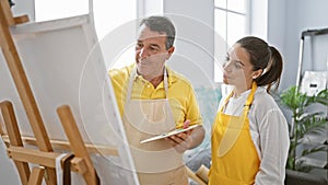 Smiling man and woman artists enjoy drawing together in cozy art studio