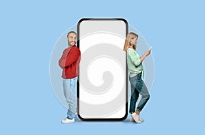 Smiling man and woman with giant smartphone