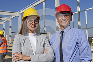 Smiling Man and Woman in Hardhats at Construction Site