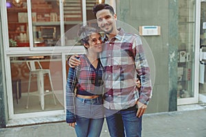 Smiling man and woman standing near cafe
