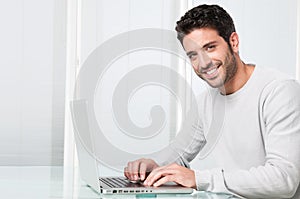 Smiling man working on laptop