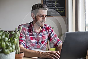 Smiling man working on laptop at home