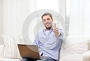 Smiling man working with laptop at home