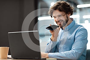Smiling man working and talking on phone at office