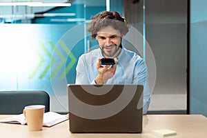 Smiling man working and talking on phone at office