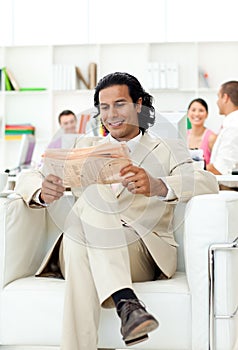 Smiling manager reading a newspaper