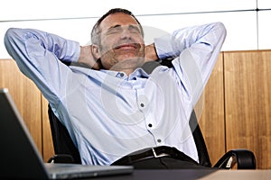 Smiling manager relaxing in office chair.