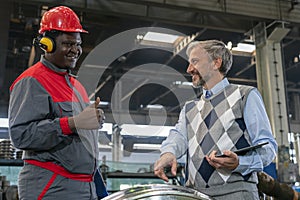 Smiling Manager Talking To African American Worker In Protective Workwear At Train Factory