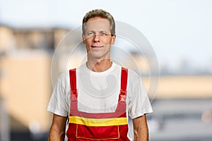 Smiling manual worker on blurred background.