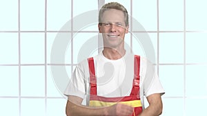 Smiling manual worker with crossed arms.