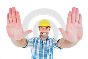 Smiling manual worker gesturing stop sign