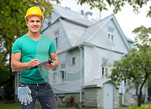 Smiling manual worker in helmet with clipboard