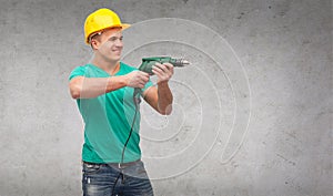 Smiling manual worker in helmet with drill machine