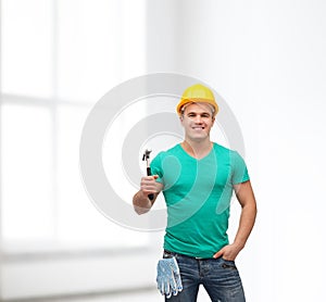 Smiling manual worker in helmet with hammer