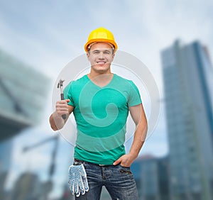 Smiling manual worker in helmet with hammer