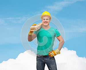 Smiling manual worker in helmet with wooden boards