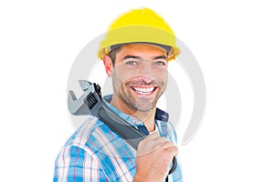 Smiling manual worker holding adjustable spanner