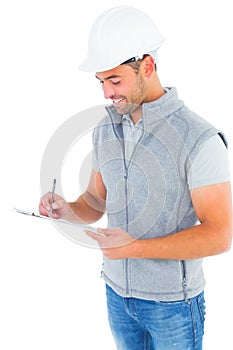 Smiling manual worker writing on clipboard