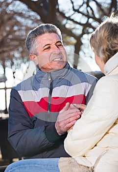 Smiling married couple holding hands each other in park