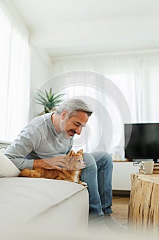 Smiling Mature adult man playing with chihuahua dog