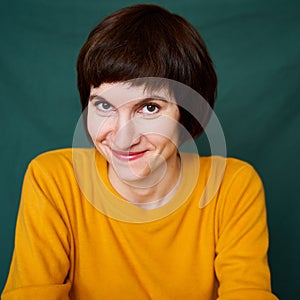 Smiling mature brunette woman looking playful and defiant, close-up portrait of middle-aged female