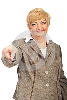 Smiling mature business woman pointing to you