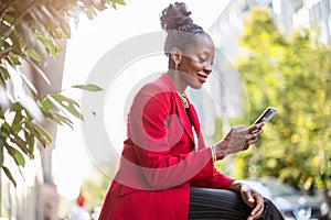 Smiling mature businesswoman using mobile phone in urban setting