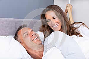 Smiling Mature Couple Lying On Bed