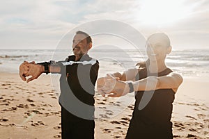 Smiling mature european man and woman doing arm exercises, stretching and warm-up