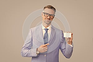 smiling mature man in glasses pointing finger on credit card and thumb up, copy space, call me