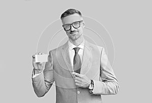 smiling mature man in glasses pointing finger on credit card and thumb up, copy space, call me